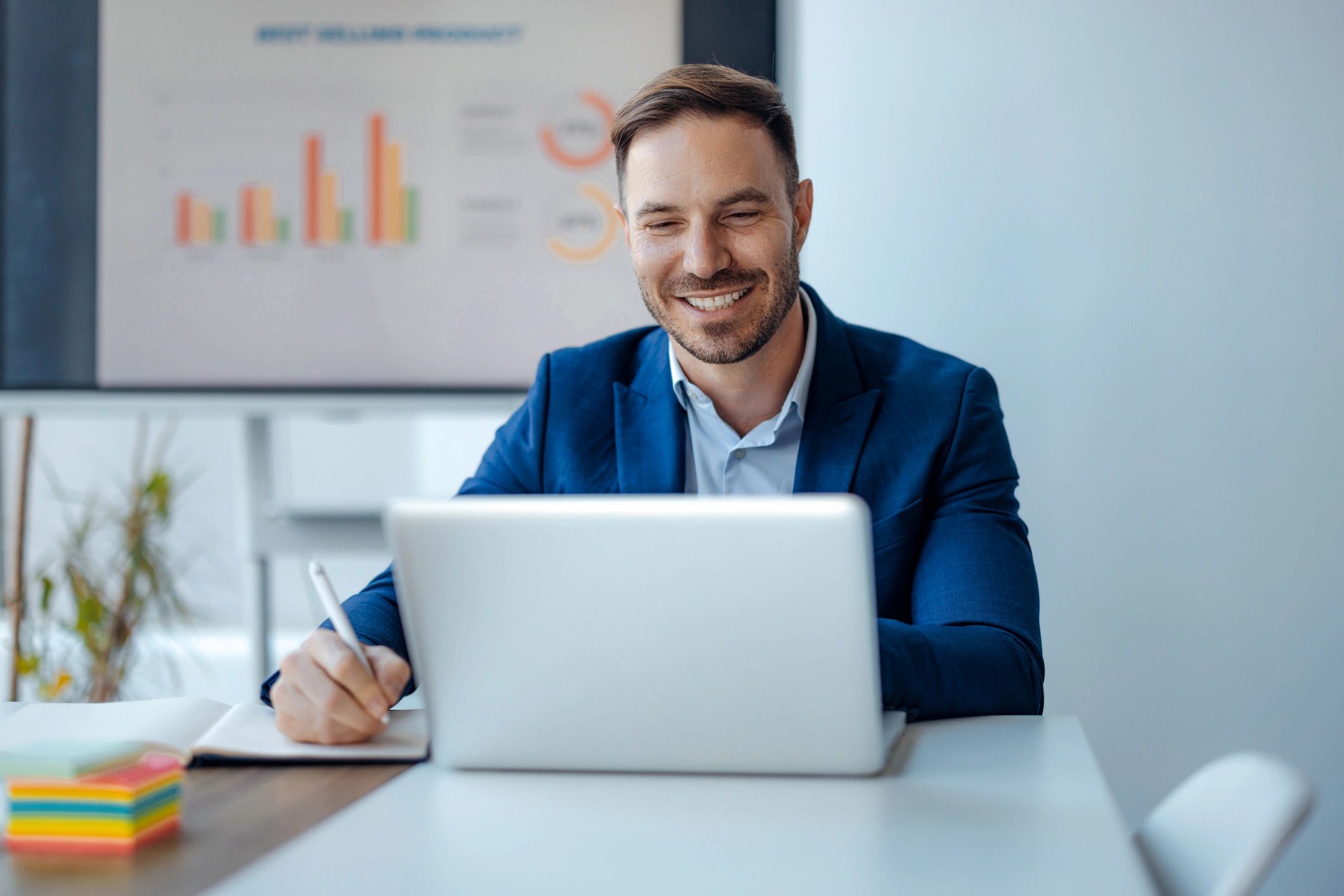 Smiling businessman working on laptop in office